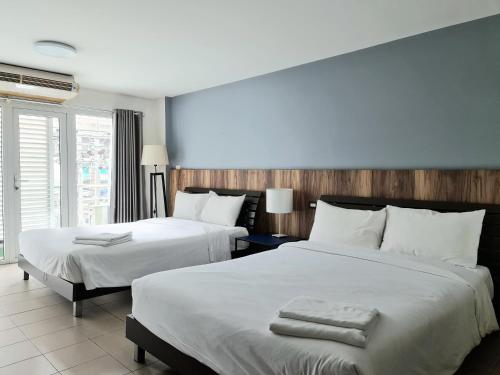 ein Hotelzimmer mit zwei Betten mit Handtüchern darauf in der Unterkunft The Studio at Sathorn Terrace in Bangkok