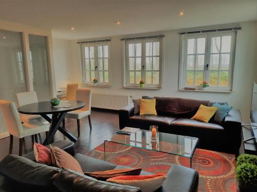 - un salon avec un canapé et une table dans l'établissement Cosy & charming holiday house in Damme, à Damme