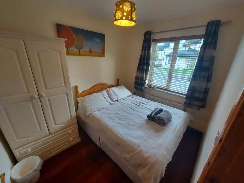 a small bedroom with a bed and a window at Village Lodge - Carlingford in Carlingford