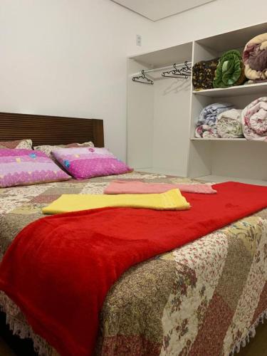 a bedroom with two beds with a red blanket on it at Residencial Henkes in Canela