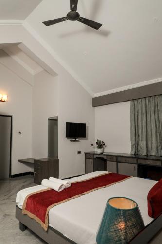 a bedroom with a large bed with a ceiling fan at Sao Domingos in Cavelossim