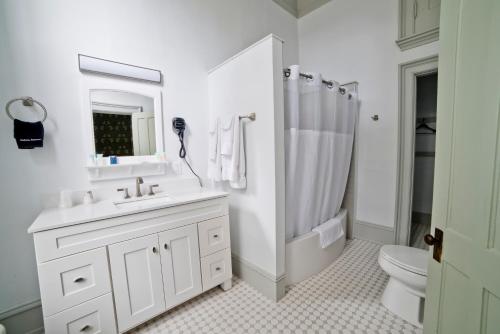 a white bathroom with a sink and a shower at Oneida Community Mansion House in Oneida