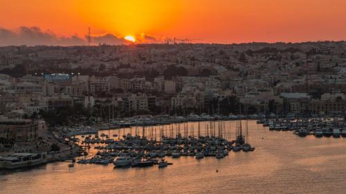 a group of boats in a harbor at sunset at Boutique Style – 2 Bedroom Apartment- Ta’Xbiex, Sliema area in Taʼ Xbiex