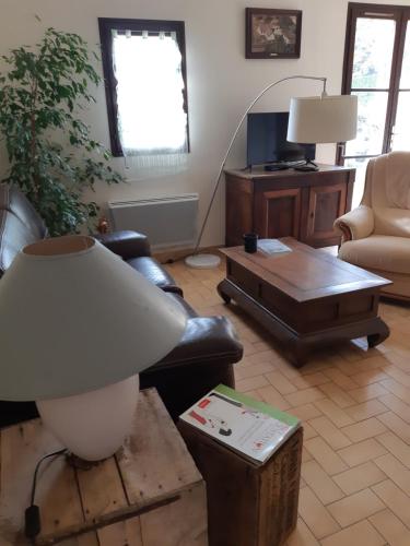 sala de estar con sofá y mesa en En Beauvoir, en Cormot-le-Grand