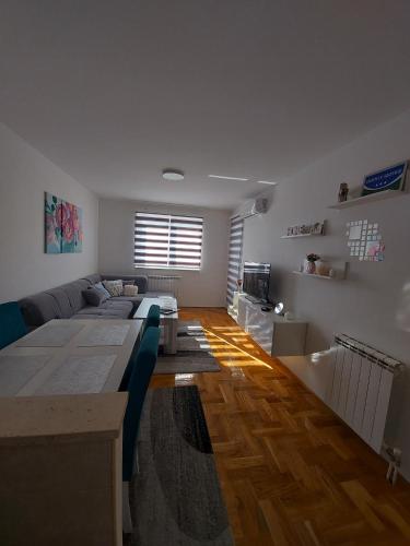ein Wohnzimmer mit einem Sofa und einem Tisch in der Unterkunft Apartman Victoria in Lukavica