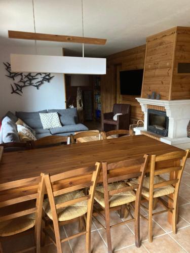 - un salon avec une grande table et des chaises en bois dans l'établissement Appart chocolat chaud 4 pièces-90m² 7 personnes, à Saint-Marcel