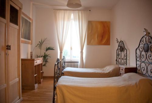 a bedroom with two twin beds and a window at apartment BB Lago Nel Pagliaio in Taino