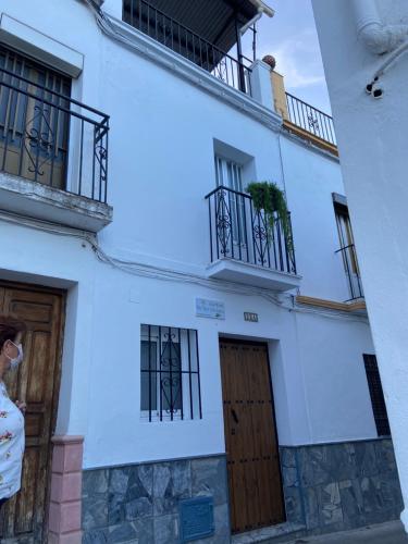 a white building with two doors and two balconies at Casa del Mar a la Sierra in Setenil