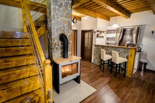 ein Wohnzimmer mit einem Holzofen und einer Küche in der Unterkunft Chaty Ski Telgárt in Telgárt