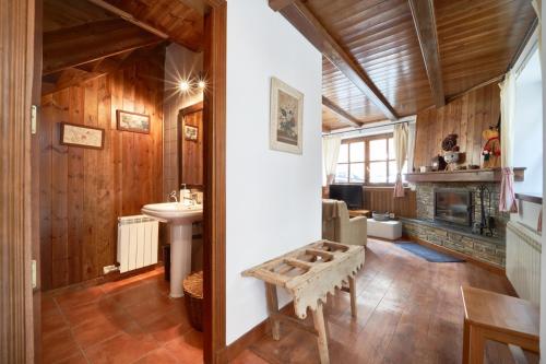 a bathroom with wooden walls and a sink and a fireplace at Mountain Chalet Baqueira Beret in Unha