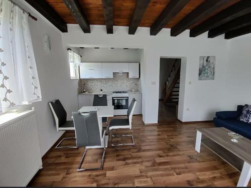 a kitchen and living room with a table and chairs at Apartman Niki in Lič