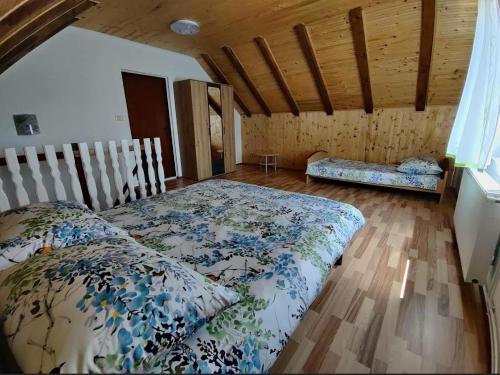 1 dormitorio con 1 cama y suelo de madera en Apartman Niki en Lič