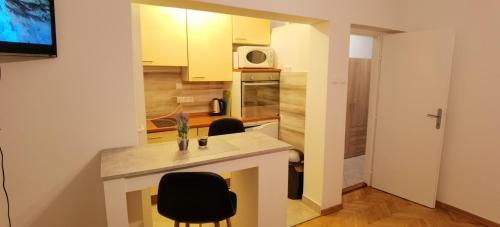 a kitchen with a counter and two chairs in a room at Studio apartman Tonka in Vinkovci