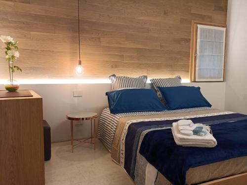 una camera da letto con un letto con cuscini blu e un tavolo di Vecchia Bastia Lodge a Castelfranco Veneto