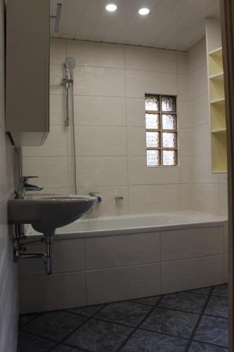 a bathroom with a sink and a bath tub at Ferienhaus Rhönpforte in Rippershausen