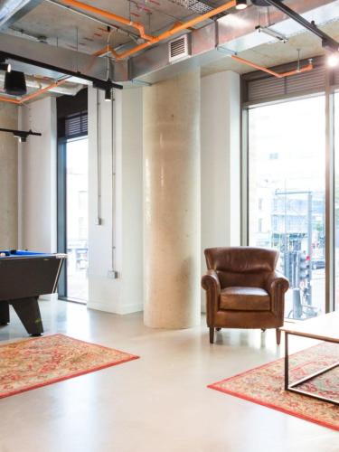 a room with a chair and a pool table at For Students Only Chic Studios and Ensuites at Chapter Highbury II in London in London