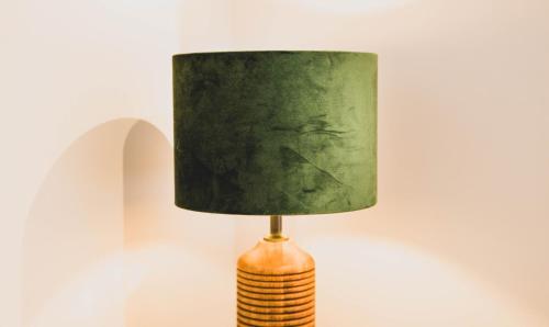 a lamp with a green lamp shade on a table at The Kepos Hotel Erlangen in Erlangen