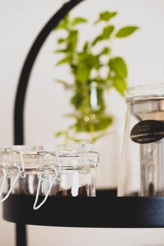 a black shelf with glasses and a vase with a plant at The Kepos Hotel Erlangen in Erlangen