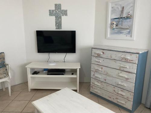 a living room with a tv and a dresser and a cross at Sea Jewel in Pearly Beach