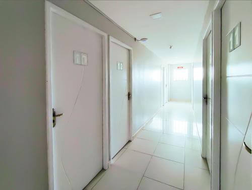 a hallway with white doors and a tile floor at Barra Nova Hotel in Saloá