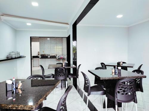 un comedor con mesas y sillas negras en Barra Nova Hotel, en Saloá