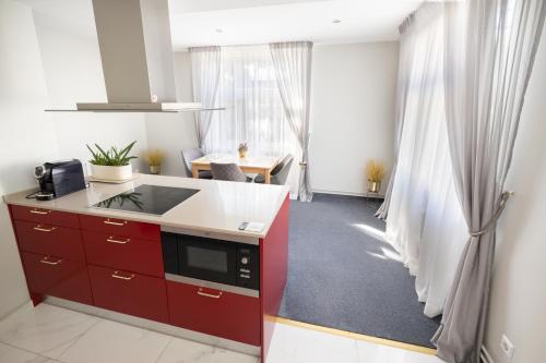a kitchen with red cabinets and a table in a room at Baltic Sea Dunes Apartments in Jūrmala