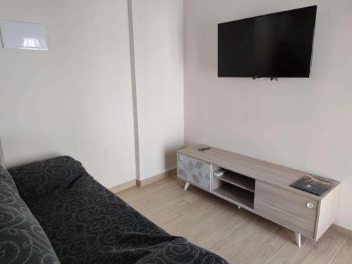 a living room with a couch and a flat screen tv at Apartamento Estels in L'Ampolla