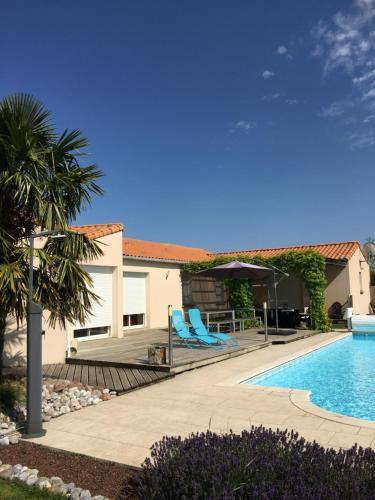 帕爾特奈的住宿－La Chambre des Amis，一座房子旁的游泳池,配有蓝色躺椅