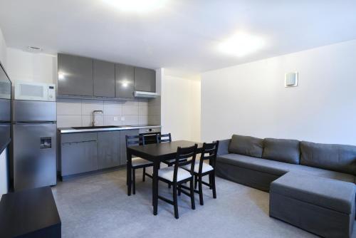 une cuisine et un salon avec un canapé et une table dans l'établissement Heptagone_2, à Saint-Quentin