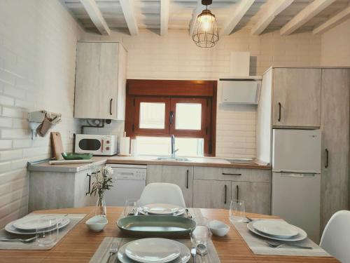 a kitchen with a wooden table with chairs and a dining room at La casita del olivo in Hervás