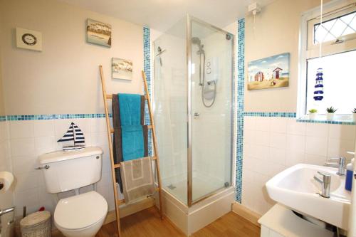 een badkamer met een douche, een toilet en een wastafel bij Peaceful Garden Apartment in Herne Bay