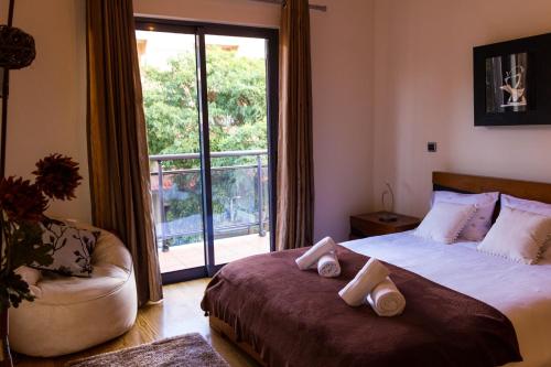 a bedroom with a bed and a couch and a window at Apartamento Batista by Horizon View Madeira in Funchal