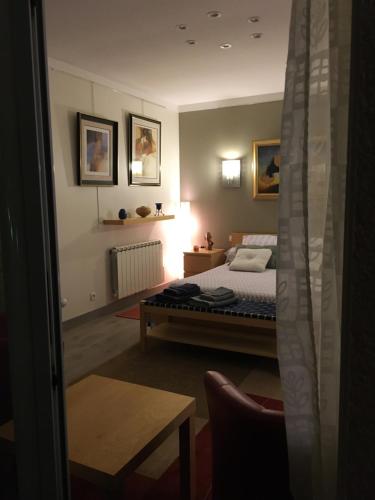 a bedroom with a bed and a table in it at La Chambre des Amis in Parthenay