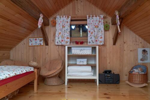 ein Schlafzimmer mit einem Bett und einem Regal im Dachgeschoss in der Unterkunft Tourist Farm Ranč Velka in Spodnja Velka