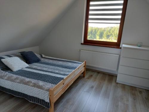 a bedroom with a bed and a window at Domek Rospuda in Rospuda