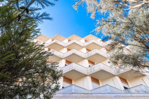 a tall white building with stairs on it at Hotel City in Milano Marittima