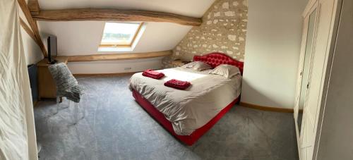 TurnyLE GITE DE VERONIQUE,jo 2024的一间卧室，床上有红色枕头