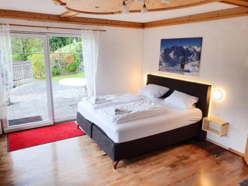 ein Schlafzimmer mit einem großen Bett und einem Balkon in der Unterkunft Alpenjuwel by PiaundDirk in Hippach