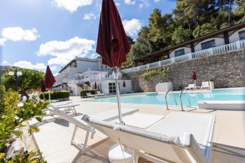 ein Hotel mit einem Pool, Stühlen und Sonnenschirmen in der Unterkunft La Locanda della Castellana adults only in Peschici