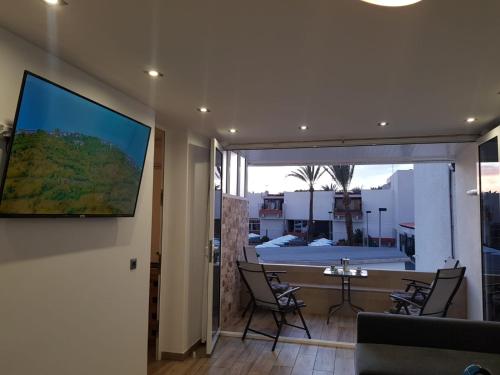 un salon avec une table et une grande fenêtre dans l'établissement Family comfortable apartment, à Arona