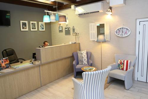 a man sitting at a counter in a waiting room at Hotel Delfin in Zadar