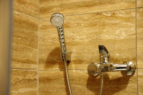 eine Dusche mit Duschkopf an der Wand in der Unterkunft Apartment Alexandar in Podgorica