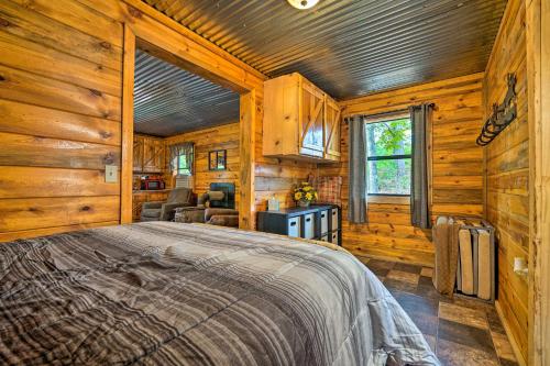 a bedroom with a bed in a wooden cabin at Wright City Cabin with Fire Pit and Forest Views! in Wright City