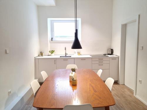 a kitchen with a wooden table and white cabinets at Apartment Emilie with parking historic city center in Merano