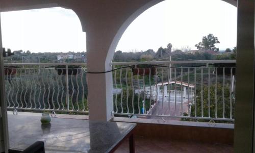 een balkon met een tafel en uitzicht op een wijngaard bij Sempre verde in Agnone Bagni