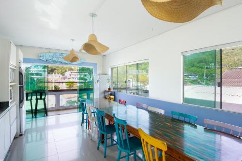 a dining room with a long table and chairs at Sea Wolf Surf Hostel in Florianópolis