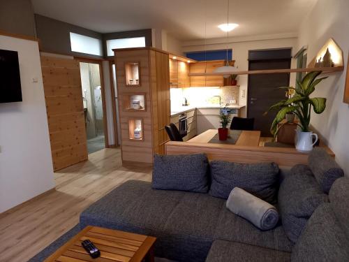 a living room with a blue couch and a kitchen at beim Tischler in Vorderstoder