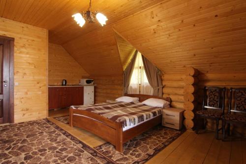a bedroom with a bed in a wooden cabin at Садиба Панська in Plav'ya