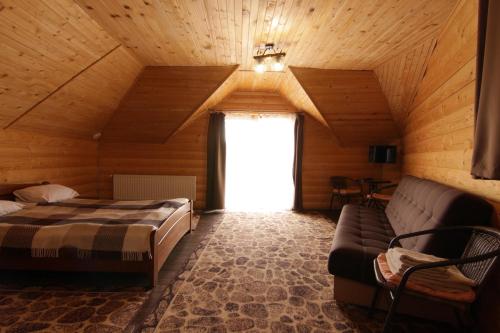 a bedroom with a bed and a couch in a room at Садиба Панська in Plav'ya