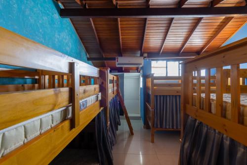 a row of wooden bunk beds in a room at Sea Wolf Surf Hostel in Florianópolis